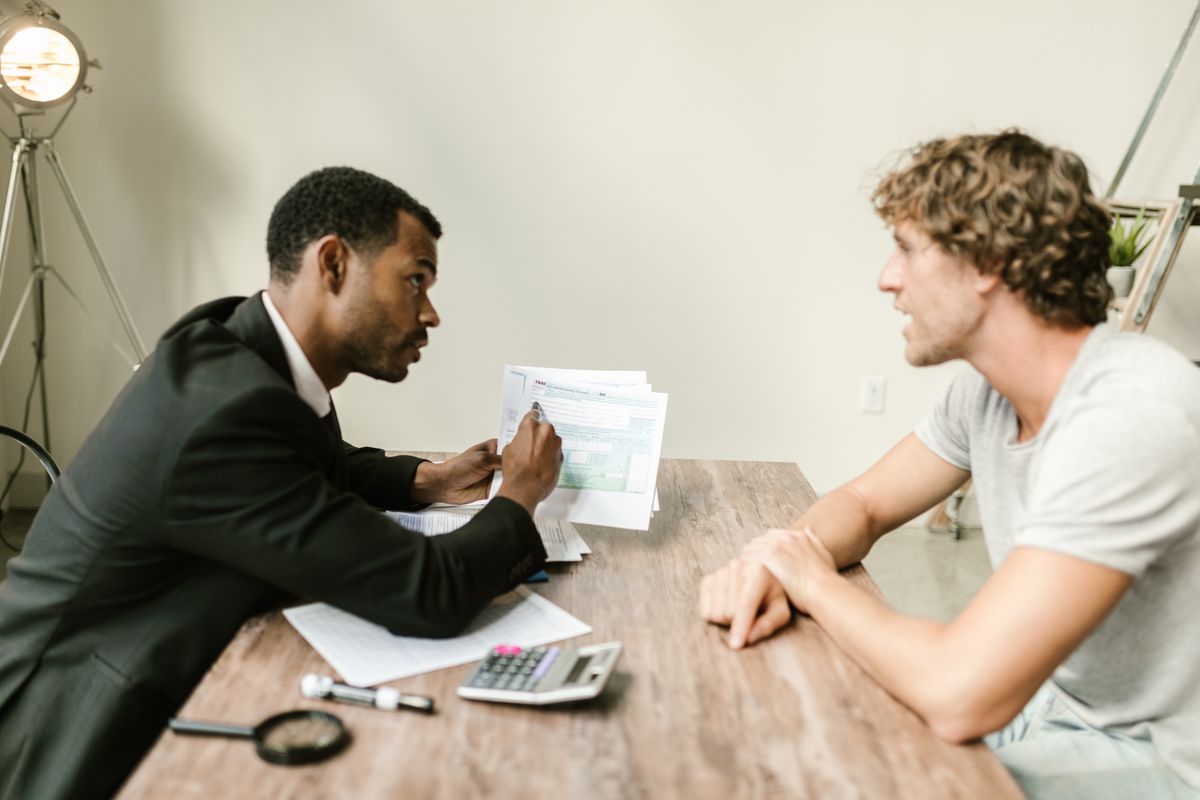 An adviser going through a document with a client across a desk