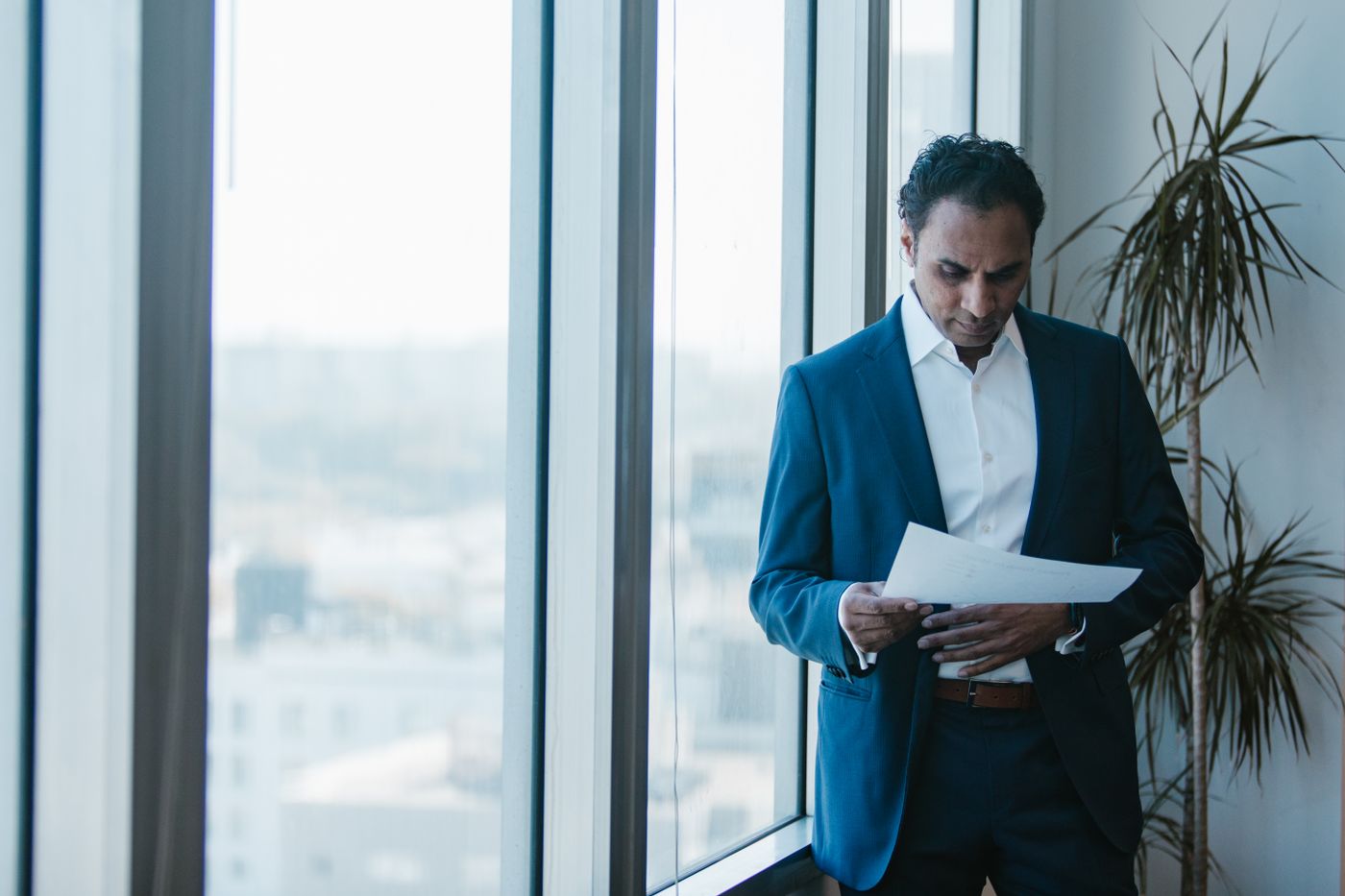 A professional reviewing documents beside an office window